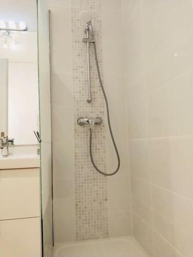 une douche avec une porte vitrée dans une salle de bain dans l'établissement Bel appartement proche de Paris - 15 minutes, à Bondy