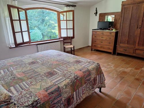a bedroom with a bed and a dresser and a window at Alla Capannina in Pieve Fosciana