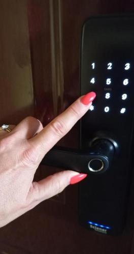 a person with their index finger on a remote control at Apartman Veki in Subotica