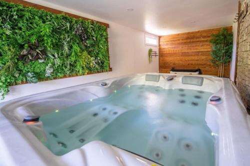 La salle de bains est pourvue d'une baignoire et d'un mur vert. dans l'établissement Campôse, authentique maison vintage avec spa, 10p, à Gérardmer