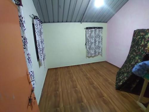 a room with white walls and a wooden floor at Torna Camp Sites in Welhe