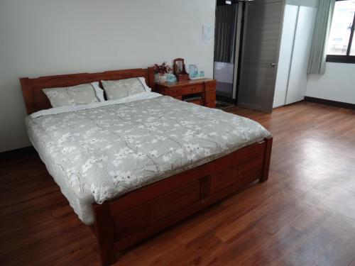 a bedroom with a bed and a wooden floor at Hoin 4 in Xigang