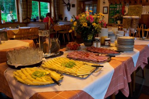 a table with many plates of food on it at Appartements Bergheim in Hirschbichl