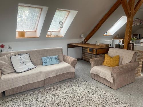 a living room with two couches and a piano at Podkrovní studio apartment pro 1-5 osob in Knínice