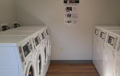 two white washing machines in a laundry room at Affordable Suites of America Portage in Portage
