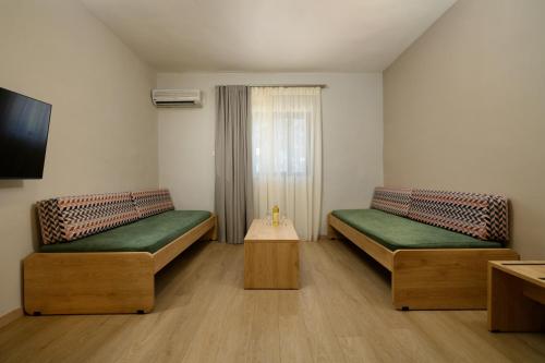 a small room with two beds and a table at Sunshine Corfu Hotel And Spa in Nisakion