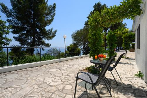 a patio with a table and chairs on a stone patio at Sunshine Corfu Hotel And Spa in Nisakion