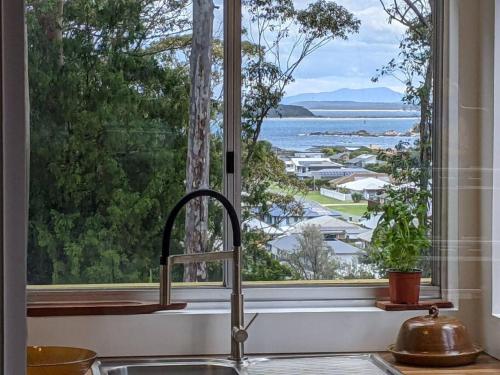 a kitchen sink with a window looking out at the water at Seascape Studio in Tomakin