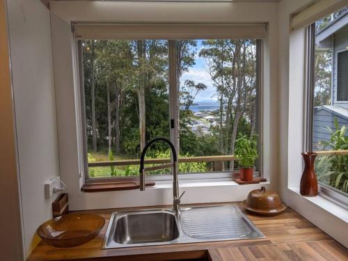 a kitchen with a sink and a large window at Seascape Studio in Tomakin