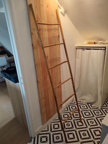 - une porte en bois dans une chambre avec une échelle dans l'établissement La halte briviste, à Brive-la-Gaillarde
