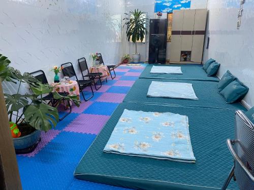 a room with blue tables and chairs and plants at Homestay giá SV gần Ga HP in Hai Phong