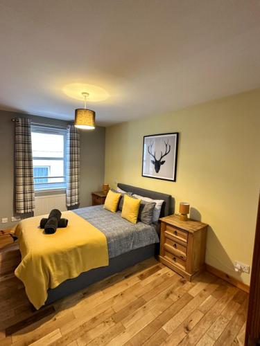 a bedroom with a bed with a yellow blanket at Metro 8 Inverness City Centre in Inverness