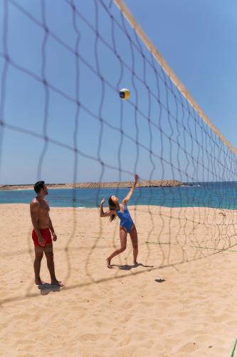 a man and a woman playing volleyball on the beach at Four Seasons Hotel Alexandria At San Stefano in Alexandria