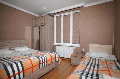 a bedroom with two beds and a window at Kottage ji in Bakuriani
