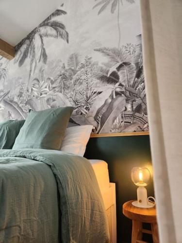 - une chambre avec un lit orné d'une fresque murale de palmiers dans l'établissement Le Garden Champ'- Duplex, jardin, à Épernay