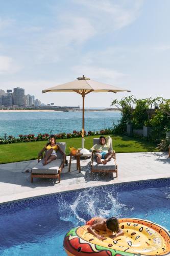 a group of people sitting in chairs by a swimming pool at Four Seasons Hotel Alexandria At San Stefano in Alexandria