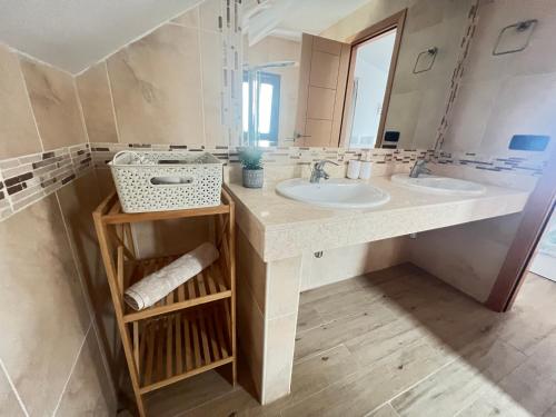 a bathroom with two sinks and a mirror at Tinajas Penthouse Views in Corralejo