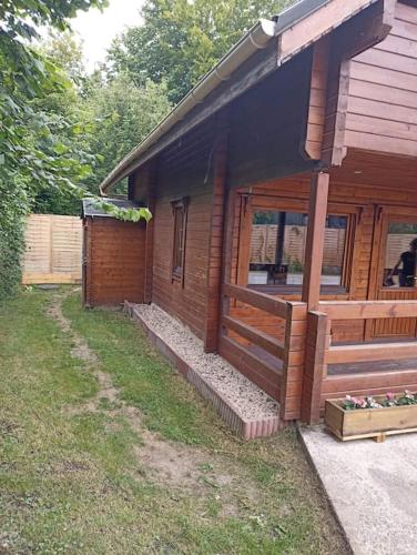 Cette maison en bois dispose d'une véranda et d'une fenêtre. dans l'établissement Chalet à la campagne, à Bury