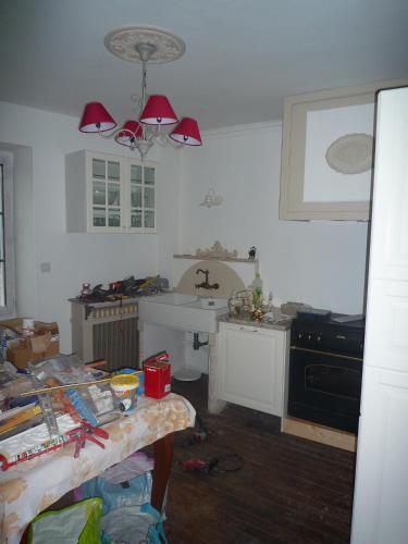 une cuisine avec une table, un évier et une cuisinière dans l'établissement Gite du Moulin des Noues, à Saint-Germain-sur-École