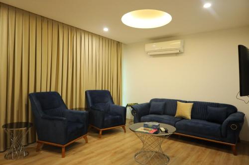 a living room with two chairs and a couch and a table at Shingelbana Resort in Rawandoz