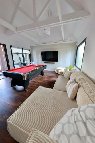 un salon avec une table de billard dans l'établissement Villa 75m2 avec Piscine et Jacuzzi privés, Sauna et Home-Cinéma à 800m des Commodités, à La Baule
