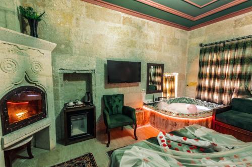 a room with a fireplace and a bed and a tub at Tafana Cave & Stone Lodge in Urgup