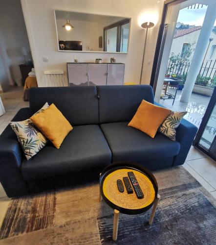 - un canapé noir avec des oreillers et une table dans le salon dans l'établissement 1BR Apartment T2 54m2 Onde Marine 2nd floor Lift Wifi AC Parking, à Port-Vendres