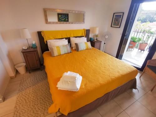- une chambre avec un lit jaune et des serviettes dans l'établissement 1BR Apartment T2 54m2 Onde Marine 2nd floor Lift Wifi AC Parking, à Port-Vendres