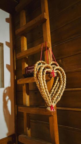 a rope heart hanging on a wooden ladder at Cabana Trei Brazi Cacica in Cacica