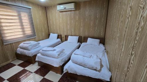 two twin beds in a small room with a window at Shingelbana Resort in Rawandoz
