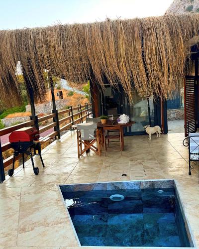 a patio with a table and a straw roof at Dolce Vita Söğüt in Marmaris