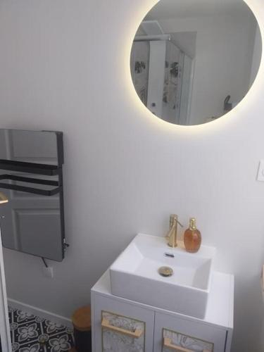 une salle de bain blanche avec un lavabo et un miroir dans l'établissement Escapade romantique dans une demeure du 18ème, à Buchères
