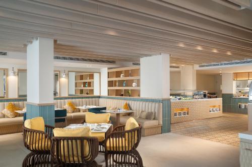 een restaurant met een tafel en stoelen en een bank bij Palma Bay Rotana Resort in El Alamein