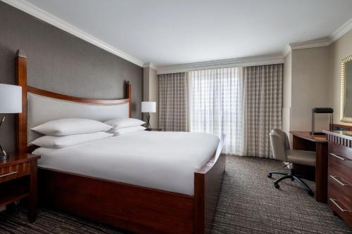 a hotel room with a large bed and a desk at Macon Marriott City Center in Macon