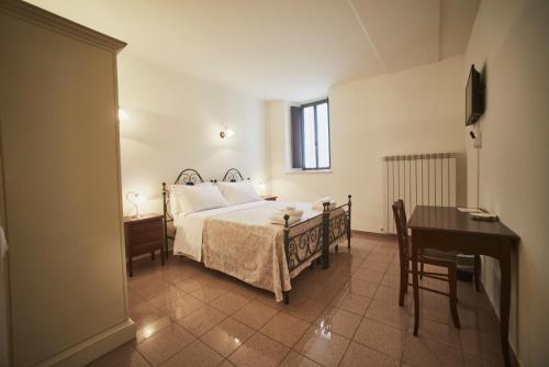 a bedroom with a bed and a table and a desk at il Monastero di Bevagna in Bevagna