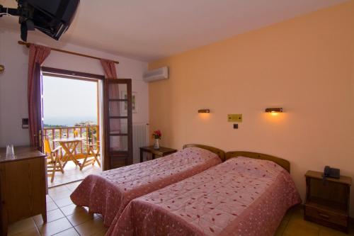 ein Schlafzimmer mit einem Bett und einem Balkon in der Unterkunft Thassos Inn in Panagia