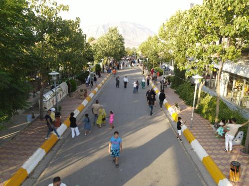 a group of people walking down a street at Shingelbana Resort in Rawandoz