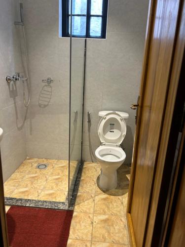 a bathroom with a toilet and a shower stall at Cozy corner in Kigali