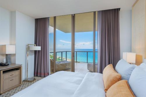 una camera da letto con un letto e vista sull'oceano di 3MM Oceanfront Residence at Finest Bal Harbour Resort - Hotel Amenities a Miami Beach