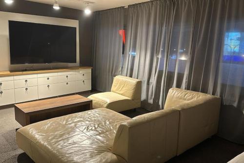 a living room with a couch and a tv at Sleepsoon1 Nord in Cologne