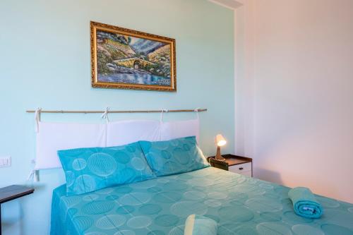 a bedroom with a blue bed and a picture on the wall at PIAZZA LAURINO Apartments in Laurino