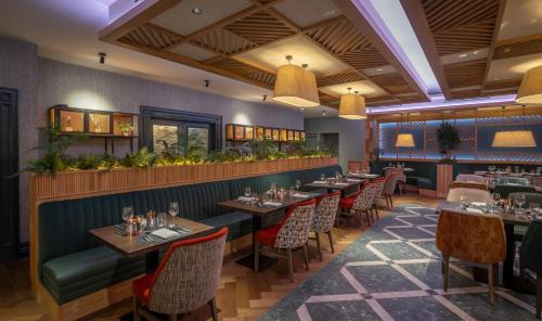 a restaurant with tables and chairs and a bar at Bracken Court Hotel in Balbriggan