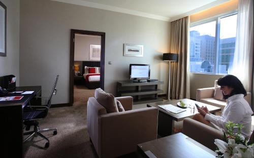 a woman sitting in a hotel room at Ramada Downtown Abu Dhabi in Abu Dhabi