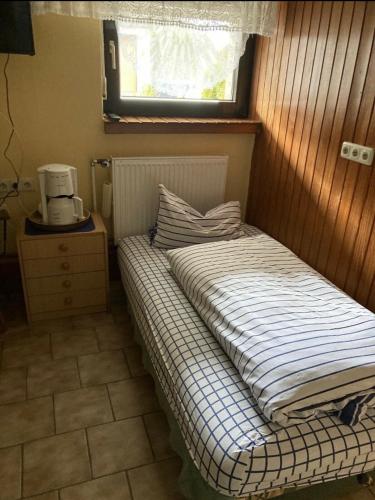 a small bed in a room with a window at Haus Schuster in Bad Salzschlirf
