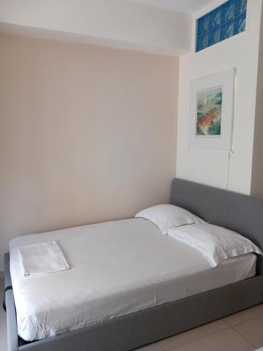 a bed in a room with a white wall at Hra in Loutraki