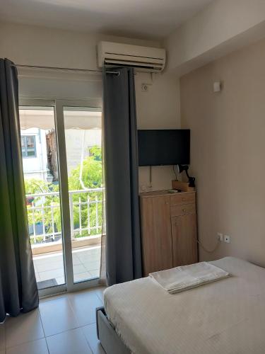 a bedroom with a bed and a view of a balcony at Hra in Loutraki