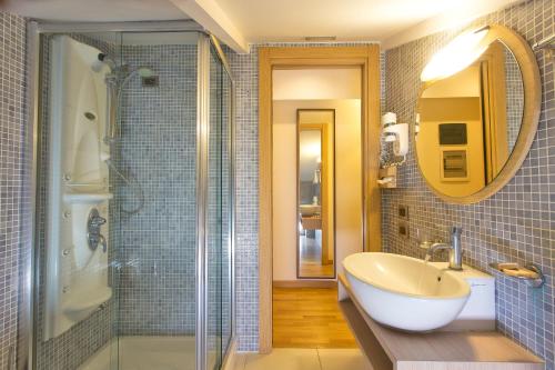 a bathroom with a tub, sink and mirror at Virgilio Grand Hotel in Sperlonga