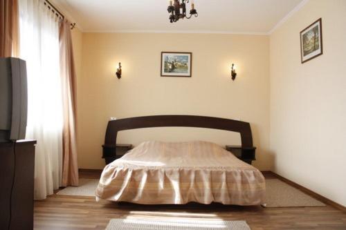 a bedroom with a bed in the corner of a room at Pension Casa Ali & Andu in Buşteni