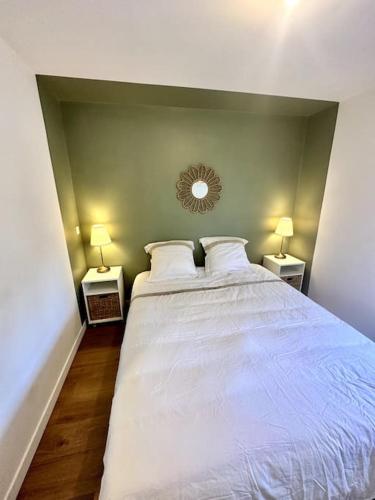 une chambre avec un grand lit blanc avec deux lampes dans l'établissement Confort près de Genève, à Annemasse