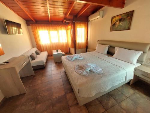 a bedroom with a large bed and a couch at Nikos Hotel in Matala